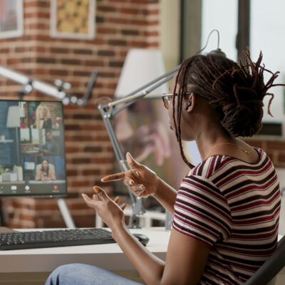 Company employee attending videocall business meeting on computer with webcam, talking to colleagues about remote work. Using online videoconference and remote teleconference call to chat.