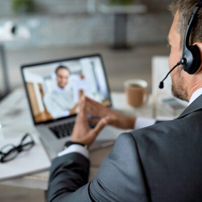 Close-up of entrepreneur using laptop while having online business meeting in the office.