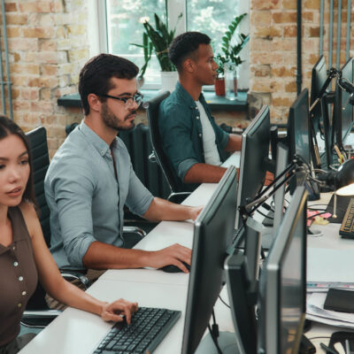 Teamwork . Group of young employees working on computers while sitting in modern open space. Job concept. Business people. Workplace