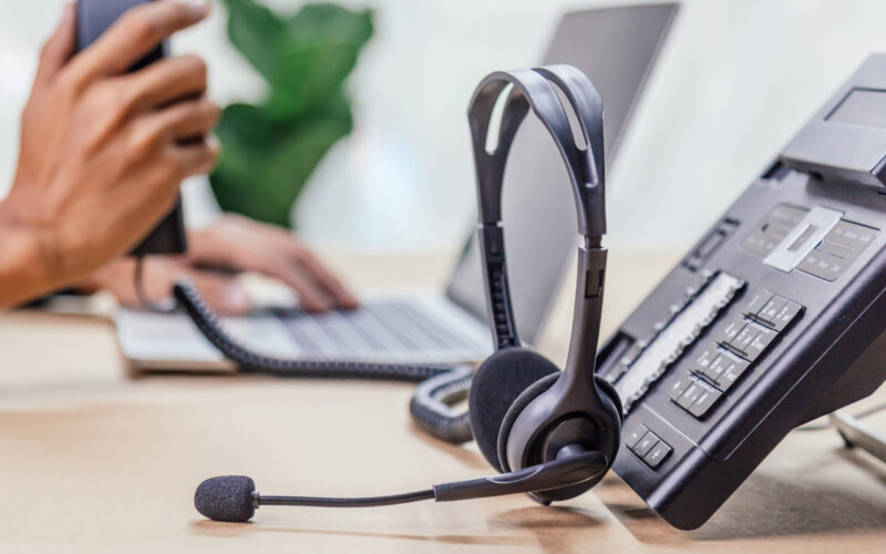 Communication support, call center and customer service help desk. telephone devices with VOIP headset in office.Customer service support (call center) concept.