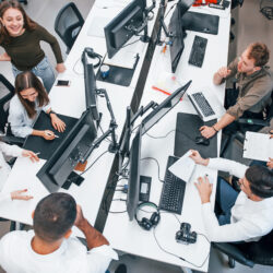 Top view of young business people that working together by computers in the modern office.